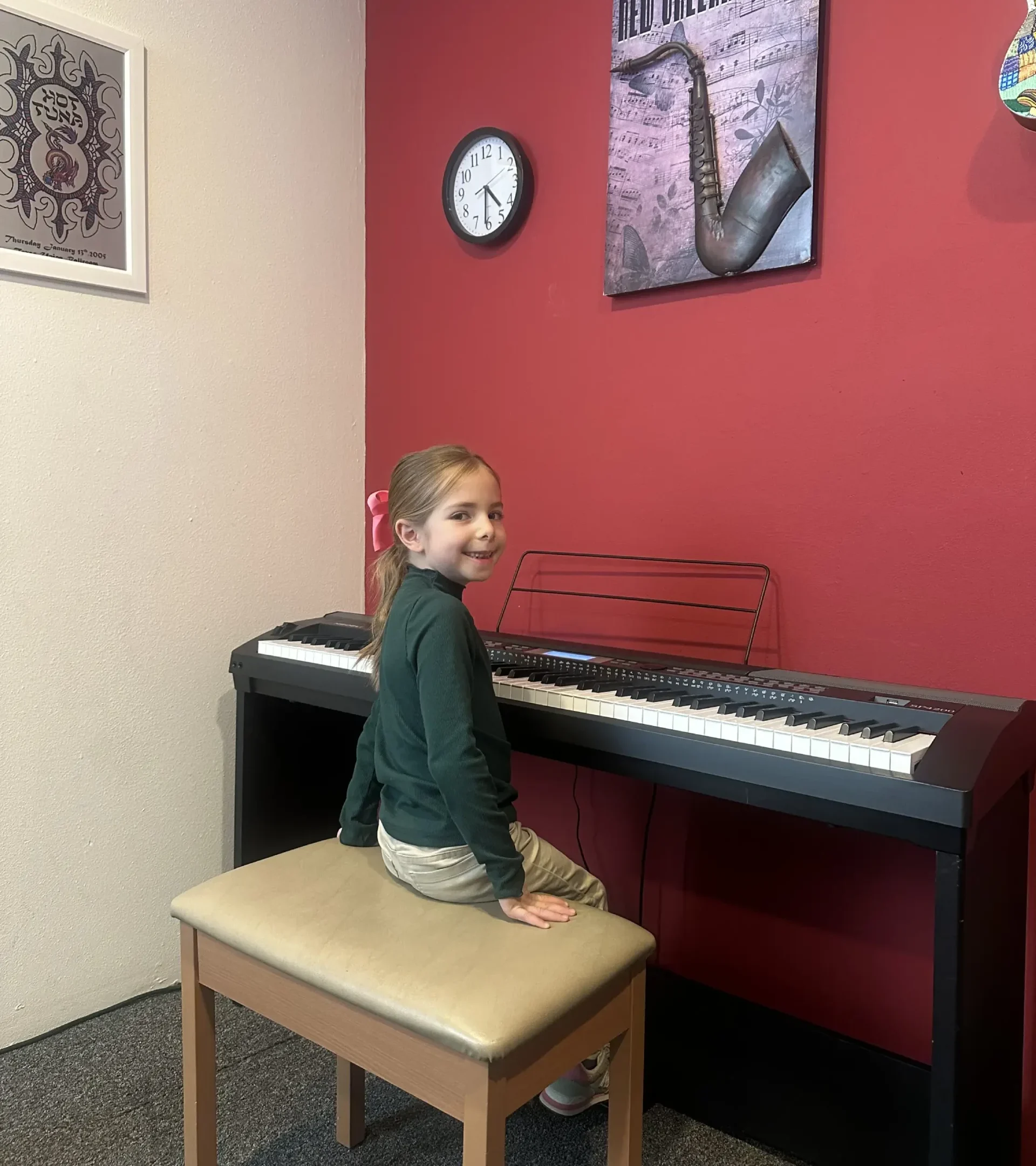 Aviva at her very first piano lesson at The Candyman Strings & Things—small hands on the keys, beginning a beautiful musical journey.